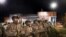 FILE - Members of the National Guard stand guard outside the Ferguson Police Department where demonstrators gathered to protest the shooting of Michael Brown in Ferguson, Mo., Nov. 28, 2014. 