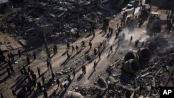 فلسطینی‌ها در رفح پس از حمله اسرائیل، در مقابل ساختمان های مسکونی و یک مسجد ویران شده گردآمده‌اند. پنجشنبه ۳ اسفند ۱۴۰۲