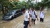 Students wade through a flood at a flooded neighborhood in Jakarta, Indonesia, Tuesday, Feb. 25, 2020. Overnight rains caused rivers to burst their banks in greater Jakarta sending muddy water into residential and commercial areas, inundating…
