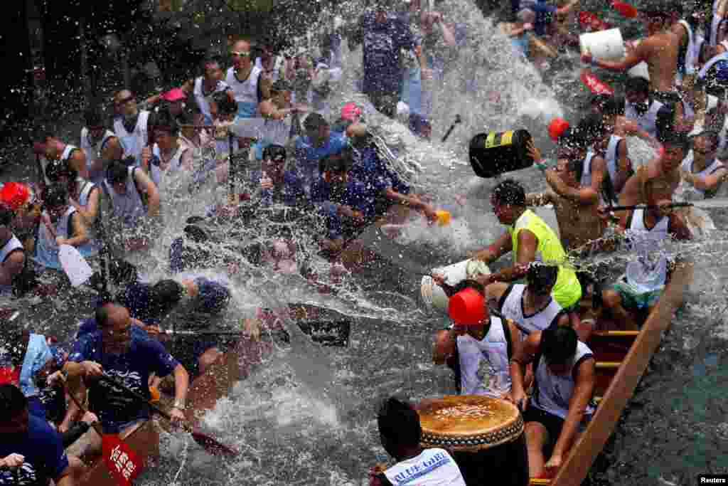អ្នក​ចូលរួម​ជះ​ទឹក​ដាក់​គ្នា​​នៅ​អំឡុងពេល​ពិធី​បុណ្យ Dragon Boat Festival នៅ​កំពង់ផែ Aberdeen ក្នុង​កោះ​ហុងកុង។