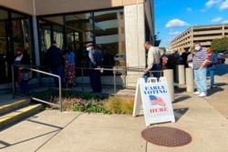 FILE - Voters line up outside a polling place in Charleston, W.Va., Oct. 21, 2020, the first day of early in-person voting in the state for the November 3 election.