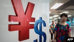 Lambang mata uang yuan (kiri) dan dolar AS di Hong Kong (13/8).