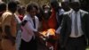 Stella Nyanzi being carried by her lawyer Nicholas Opio and friends outside court after the Magistrates Court granted her bail in Kampala Uganda, May 10, 2017. (Photo: H. Athumani/VOA)