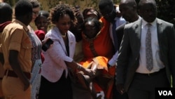 Stella Nyanzi being carried by her lawyer Nicholas Opio and friends outside court after the Magistrates Court granted her bail in Kampala Uganda, May 10, 2017. (Photo: H. Athumani/VOA)