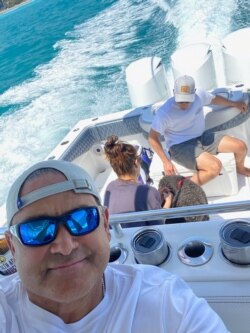 Carlos Gavidia, his family and their two dogs on their boat, SISU, crusing on the Atlantic Ocean the first Saturday after they recovered.