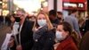 Shoppers, some wearing face coverings, cross Oxford Street in central London on Dec. 4, 2021, as compulsory mask wearing in shops has been reintroduced in England as fears rise over the Omicron variant of the coronavirus.