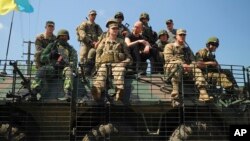 3일 우크라아나 서부 리비우에서 미국-우크라이나 연합 군사훈련이 실시된 가운데, 아르세니 야체뉵 우크라이나 총리(가운데)가 군인들과 탱크 위에 앉아서 훈련을 지켜보고 있다. 