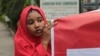 FILE - A campaigner from "#Bring Back Our Girls" hold a banner during a rally calling for the release of the Chibok school girls who were abducted by the Boko Haram militants, outside the Cameroon Embassy in Abuja.