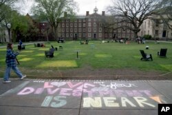 A message in chalk decorates a sidewalk after an encampment protesting the Israel-Hamas war was taken down at Brown University, Tuesday, April 30, 2024, in Providence, R.I. (AP Photo/David Goldman)