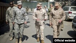 Petinggi militer AS, Jenderal Martin Dempsey (kedua dari kiri) melakukan peninjauan di Afghanistan. Pesawat Jenderal Dempsey terkena serangan roket Taliban hari Selasa (21/8). 