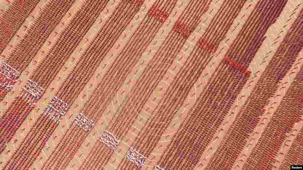 路透社的图片说明大意是，中国河南省登封市武术学校的学生操练，表演少林功夫（2016年4月7日）。笔者进一步研究发现，这张航拍照片显示少林塔沟武术学校的万千学员在练功场上，场景壮观。