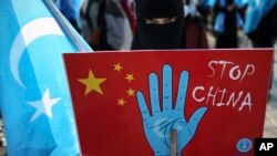 资料照：在土耳其首都伊斯坦布尔的维吾尔人手举抗议中国的标语牌参加示威集会。（2021年3月25日）