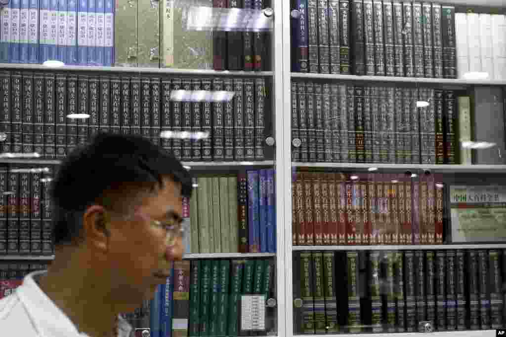 一名中国人在北京一家书店走过展示中国百科全书的书架（2017年5月4日）。在对广受欢迎的网络资源维基百科的大部分内容实施封锁的13年后，中国政府雇了几万名研究人员编纂它自己的网络百科。与由用户自己撰写和更新维基百科不同，中国当局对参与中文版网络百科编纂的研究人员进行了选拔。公众不许改变或修改其中的文章。 维基百科的部分内容可以在中国看到，但是使用者无法接触到政治上敏感的题目，例如香港特别行政区或西藏等。