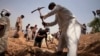 FILE - Members of the Ahmadiyya Muslim community dig graves for victims in Chenab Nagar, in Punjab's Chiniot district, about 200 km (124 miles) northwest of Lahore, May 29, 2010. Gunmen attacked Ahmadiyya worshippers in two Lahore mosques the day before, taking hostages and killing at least 70 people, officials said. 
