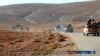FILE - This image posted online on Saturday, Dec. 10, 2016, by supporters of the Islamic State militant group on an anonymous photo sharing website, purports to show a convoy of vehicles of IS driving in a desert area of east of Palmyra city, in Homs, Syr
