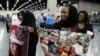 Mourners hold photos of Muhammad Ali after his Jenazah, a traditional Islamic service, at Freedom Hall in Louisville, Ky., June 9, 2016.