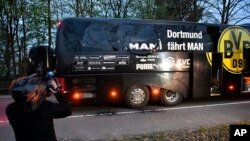 Un cameraman filamant le bus du Borussia Dortmund après l'explosion qui à endommagé le bus avant le match des quarts de finale de la ligue des champions contre l'AS Monaco, Allemagne le 11 avril 2017 (AP Photo/Martin Meissner)