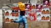 A woman walks past a wall covered with campaign posters on a street in Kenya's capital Nairobi March 3, 2013.