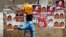 A woman walks past a wall covered with campaign posters on a street in Kenya's capital Nairobi March 3, 2013.