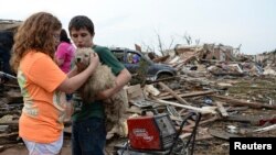 Anak-anak di Moore, Oklahoma, menenangkan anjing mereka setelah tornado melanda daerah tersebut Senin (20/5). 