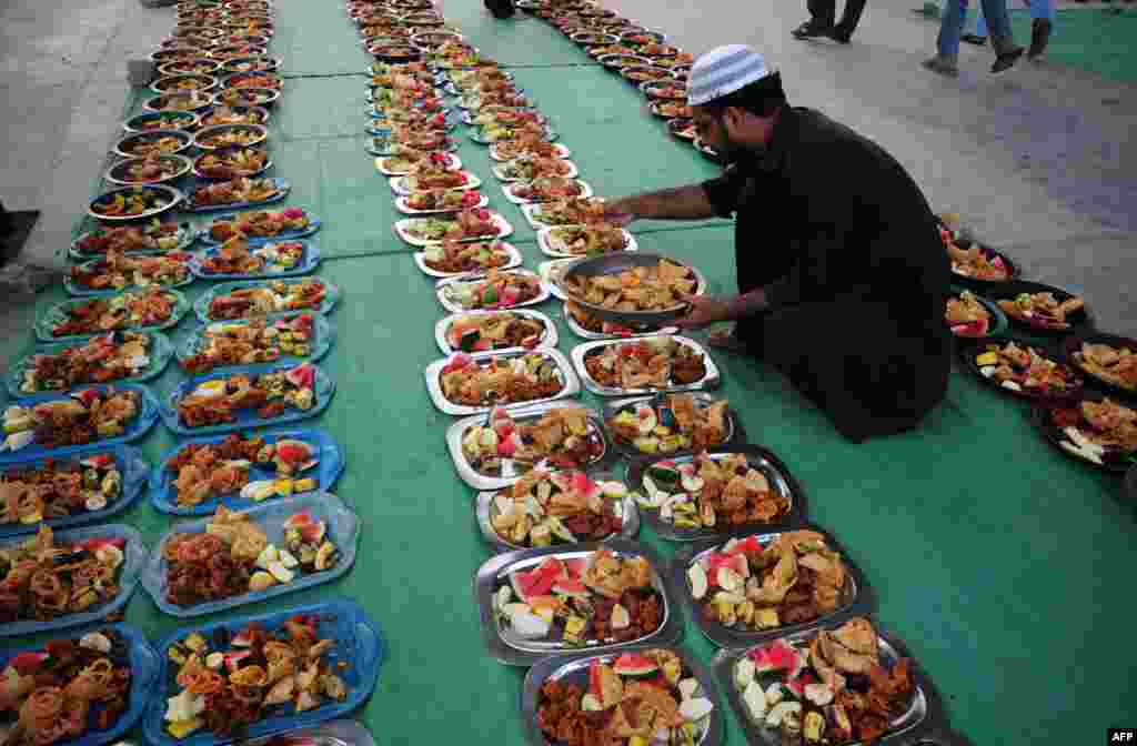 Seorang pria mempersiapkan makanan berbuka bagi umat muslim untuk acara Iftar (buka puasa) selama bulan Ramadhan di masjid di Karachi, Pakistan.