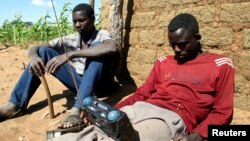 FILE - Zimbabweans listen to a radio for an announcement of election results in Umguza, Apr. 1, 2008. 