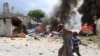 A Somali girl and her brother run to safety near the scene of a blast in Mogadishu, April 14, 2013.