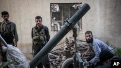 Anggota Tentara Pembebasan Suriah mengisi tabung mortir dalam pertempuran di desa Kafr Nboudah, provinsi Idlib, Suriah utara. (Foto: AP)