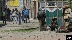 Des manifestants lancent des pierres sur des éléments des forces de sécurité indiennes devant un bureau de vote lors d'une élection partielle au Cachemire indien, le 9 avril 2017.