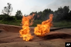 A burning flare is visible at an oil extraction area located in Moanda, Democratic Republic of the Congo, Saturday, Dec. 23, 2023. (AP Photo/Mosa'ab Elshamy)