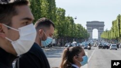 随着法国逐步解除Covid-19封锁，人们戴上口罩以帮助遏制冠状病毒在巴黎香榭丽舍大道上的传播。(2020年5月16日)