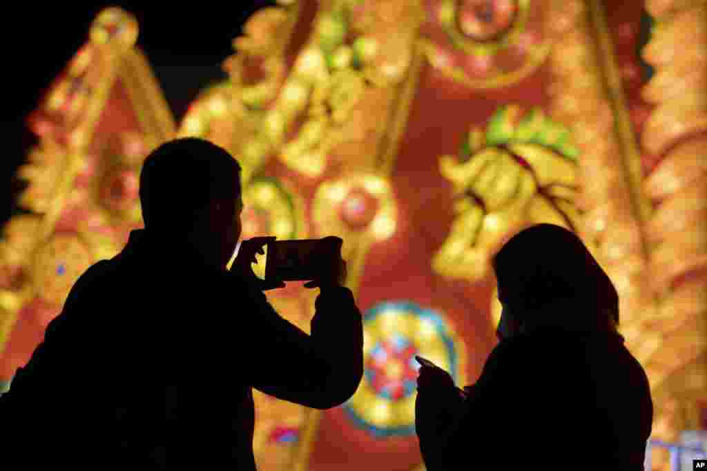 在北京，游客拍摄元宵节灯饰（2017年2月10日）