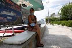 A girl sells tickets for a boat trip as coronavirus disease (COVID-19) heavily affects tourism in Budva, Montenegro, August 8, 2020.