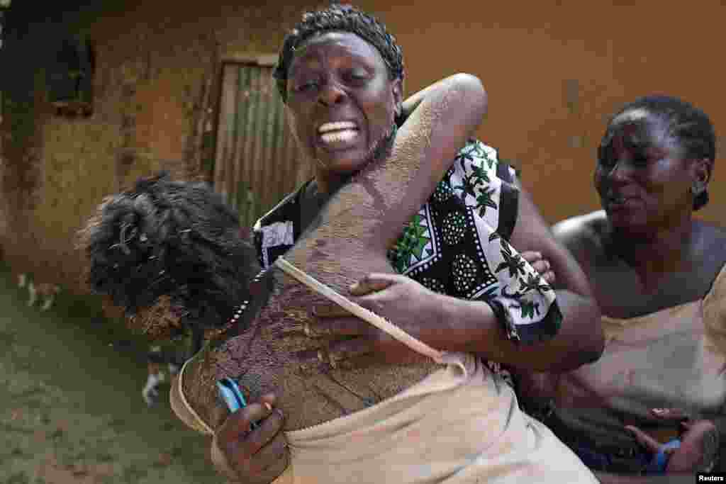 Women embrace in grief after an attack in Kibusu village in the Tana Delta region of the Kenya, January 10, 2013. 