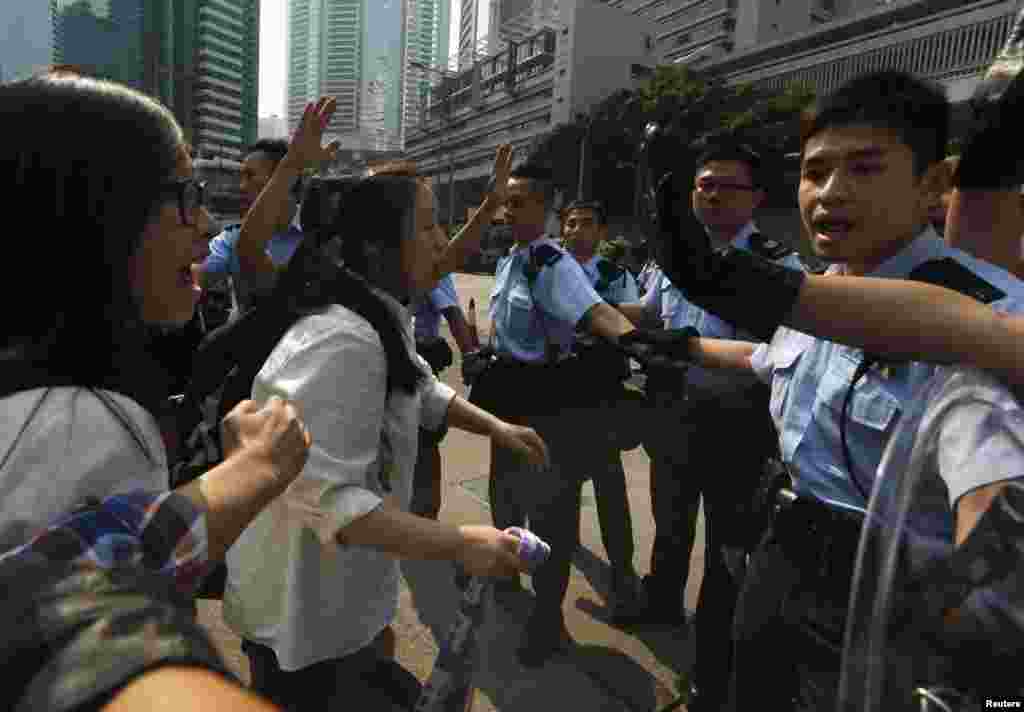 Para demonstran pro-demokrasi bereaksi saat polisi menghalangi mereka memasuki jalan utama menuju distrik keuangan Central di Hong Kong (14/10). 