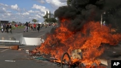 Demonstrators create a flaming barricade with chairs taken from the Ministry of Agriculture during an anti-government protest in Brasilia, Brazil, May 24, 2017. Brazil’s president ordered federal troops to restore order in the country’s capital following the evacuation of some ministries during clashes between police and protesters who are seeking the leader’s ouster.