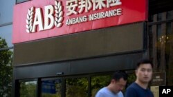 2017年6月14日，人们走过安邦保险集团驻北京办事处的入口。