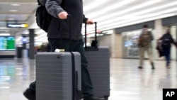 一名乘客走在维吉尼亚州杜勒斯国际机场的航站楼（ 2019年3月26日）。