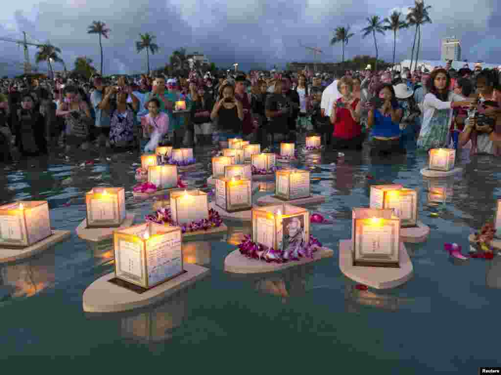 Warga Hawaii, AS memotret lentera yang mengambang di air, yang diperuntukkan guna mengenang para korban pada peringatan Hari Pahlawan di Honolulu, Hawaii.