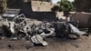 Children look at a charred pickup trucks used by Islamist rebels in Diabaly, January 21, 2013.