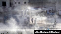 이라크 북부 키르쿠크에서 이슬람 수니파 무장조직 ISIL이 쿠르드 병력이 지키고 있는 건물을 공격했다. 건물에서 연기가 치솟고 있다.