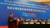 FILE - China's Finance Minister Lou Jiwei (L) gives a speech with the guests of the signing ceremony of the Asian Infrastructure Investment Bank at the Great Hall of the People in Beijing, Oct. 24, 2014. 