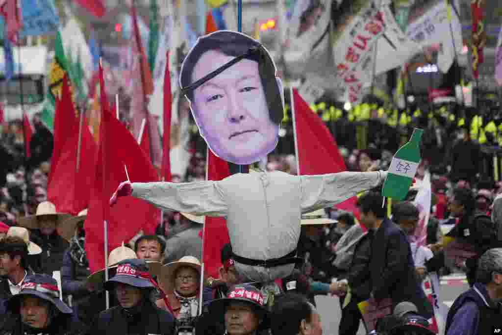 Members of the national federation of farmers and the Korean Confederation of Trade Unions march with an effigy of South Korean President Yoon Suk Yeol during a rally to demand the suspension of rice imports and Yoon's resignation in Seoul, South Korea.