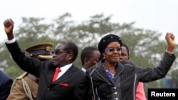 FILE: Zimbabwean President Robert Mugabe and his wife Grace wave to supporters and guests during celebrations to mark his 90th birthday, Marondera,Feb. 23,2014.