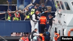 Migrants disembark after arriving at Dover harbor, in Dover, Britain, Aug. 12, 2020.