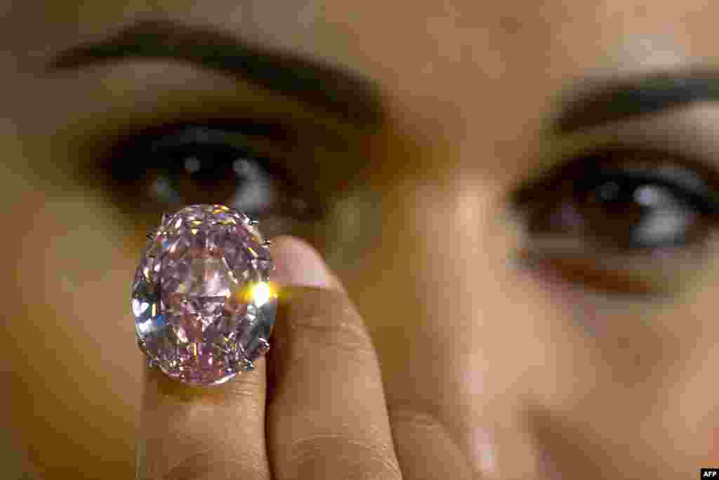 Seorang model menunjukkan berlian 59,6 karat warna pink yang akan dilelang oleh badan lelang Sotheby di kota Jenewa, Swiss dengan harga yang diminta sebesar 60 juta dolar AS.