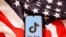 资料照： 美国国旗和手机上显示的Tiktok标识