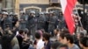 Police stand guard as anti-government protesters block a main highway in Beirut, Lebanon, Nov. 4, 2019.
