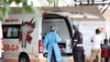 Des agents de santé discutent près d'une ambulance sur le parking de l'hôpital académique Steve Biko à Pretoria, en Afrique du Sud, le 11 janvier 2021. 