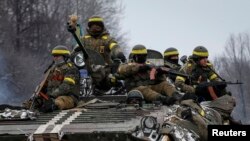 Members of the Ukrainian armed forces ride on an armoured personnel carrier (APC) near Debaltseve, eastern Ukraine, February 10, 2015. Ukrainian President Petro Poroshenko said peace talks in Minsk on Wednesday were one of the last chances to declare an u